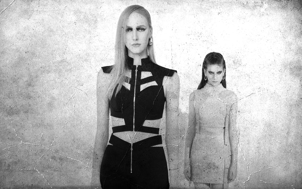 Two FlyandFall models with neutral expressions in futuristic women's fashion, illustrating the serious aesthetic challenged by Wearable Futurism.
