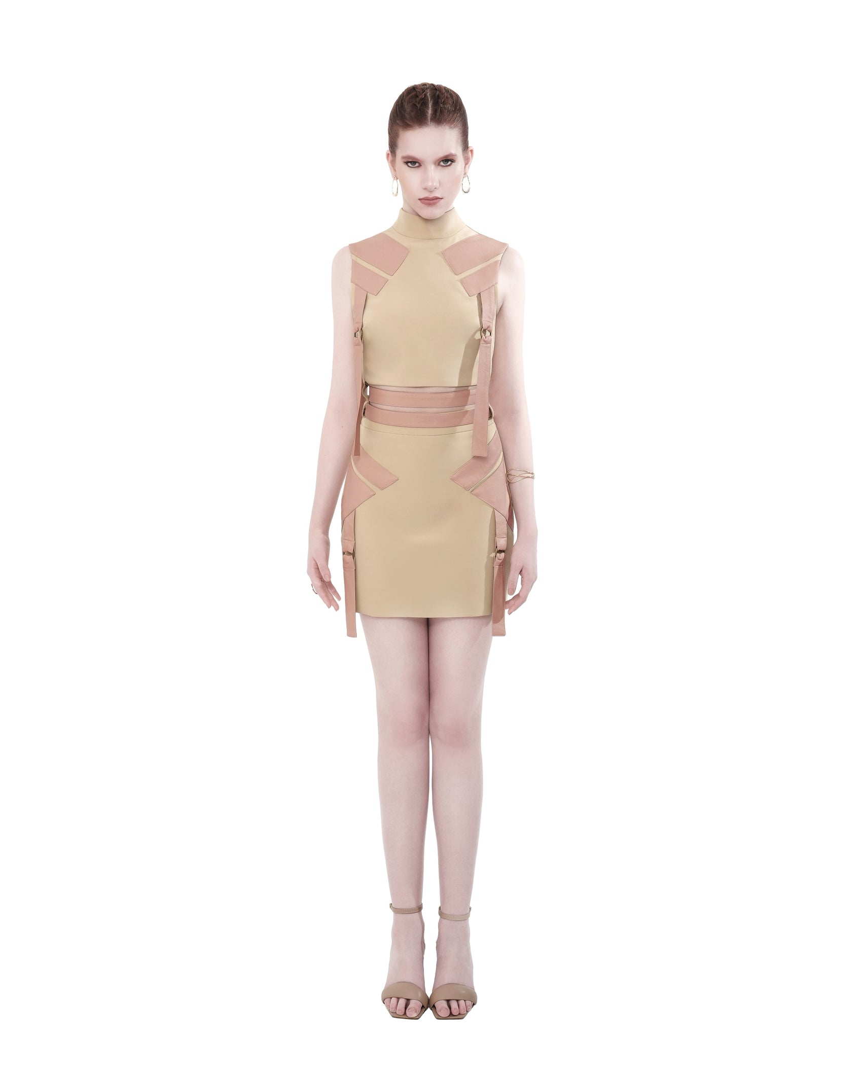 Model wearing FlyandFall's beige mock neck top and mini skirt set, featuring structured lines and functional side belts, front view.