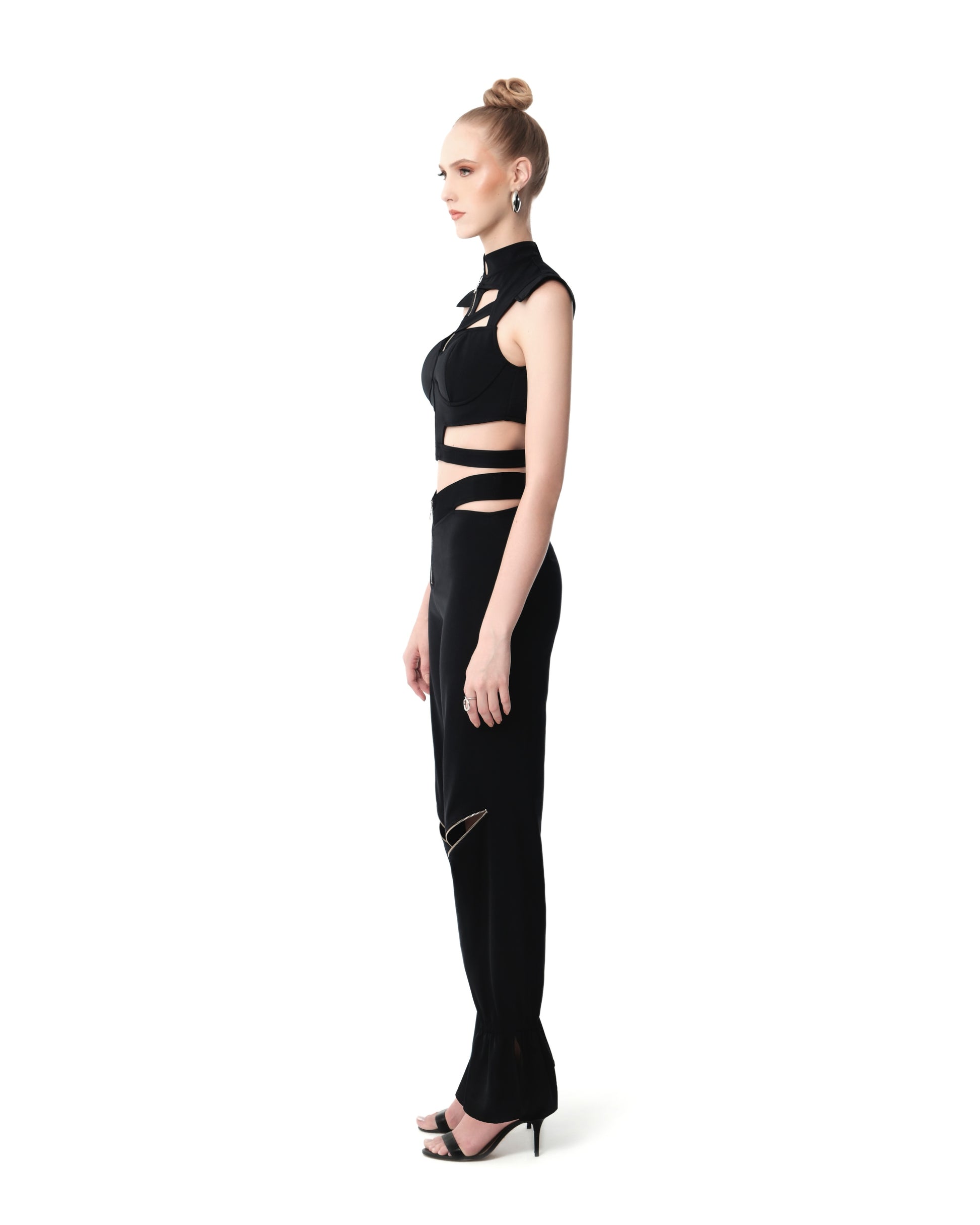 Side angle highlighting FlyandFall’s asymmetric crop top and flared pants with bold zipper details.