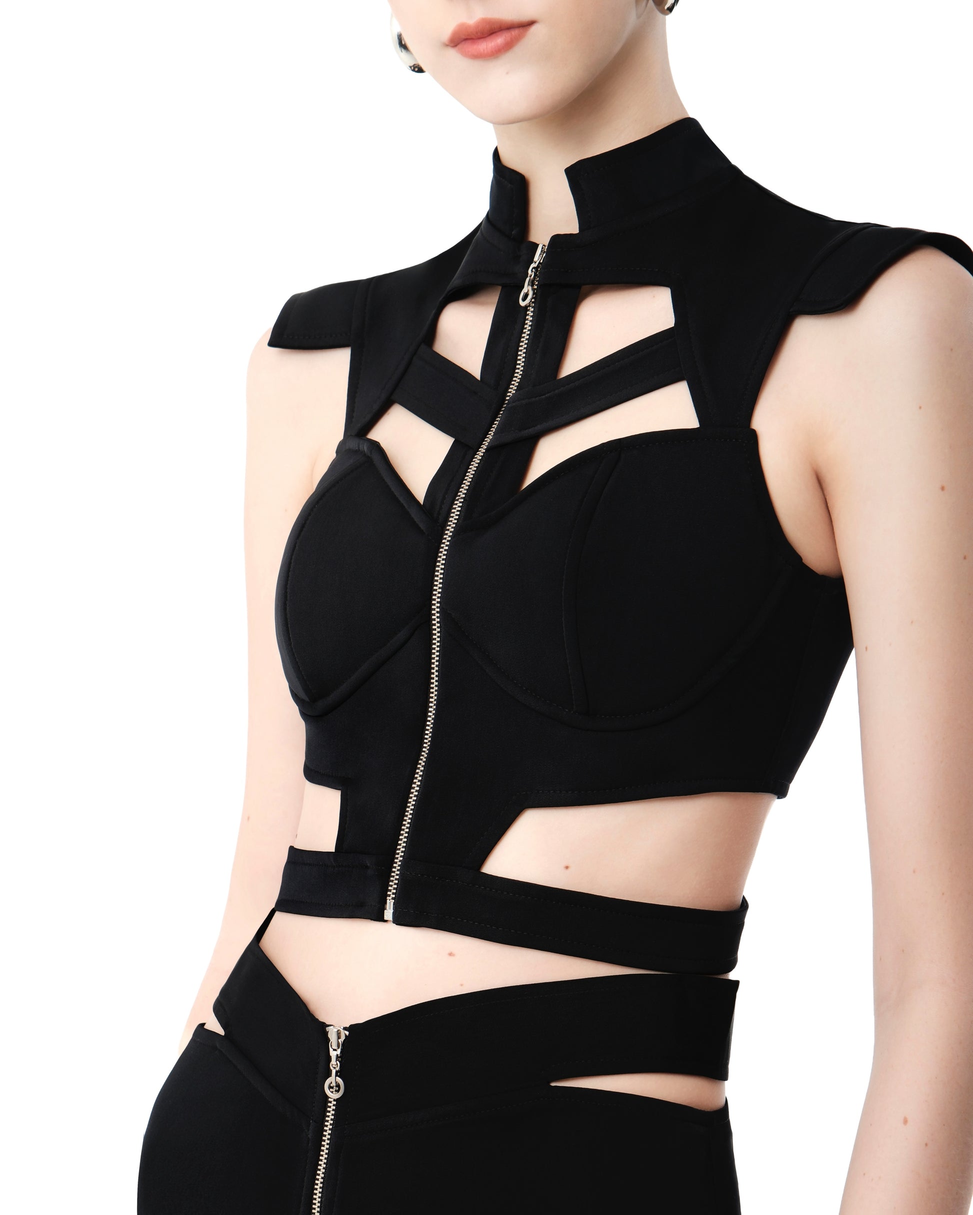 Detail of FlyandFall’s geometric crop top with a sharp neckline and exposed central zipper.