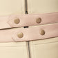 Detail of FlyandFall's gold-toned snap buttons and zipper at the waist, showcasing the garment’s finish.