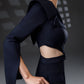 Close-up of NERIS dark blue asymmetric cutout dress showing the sculptural shoulder detail, single long sleeve and waist cutout