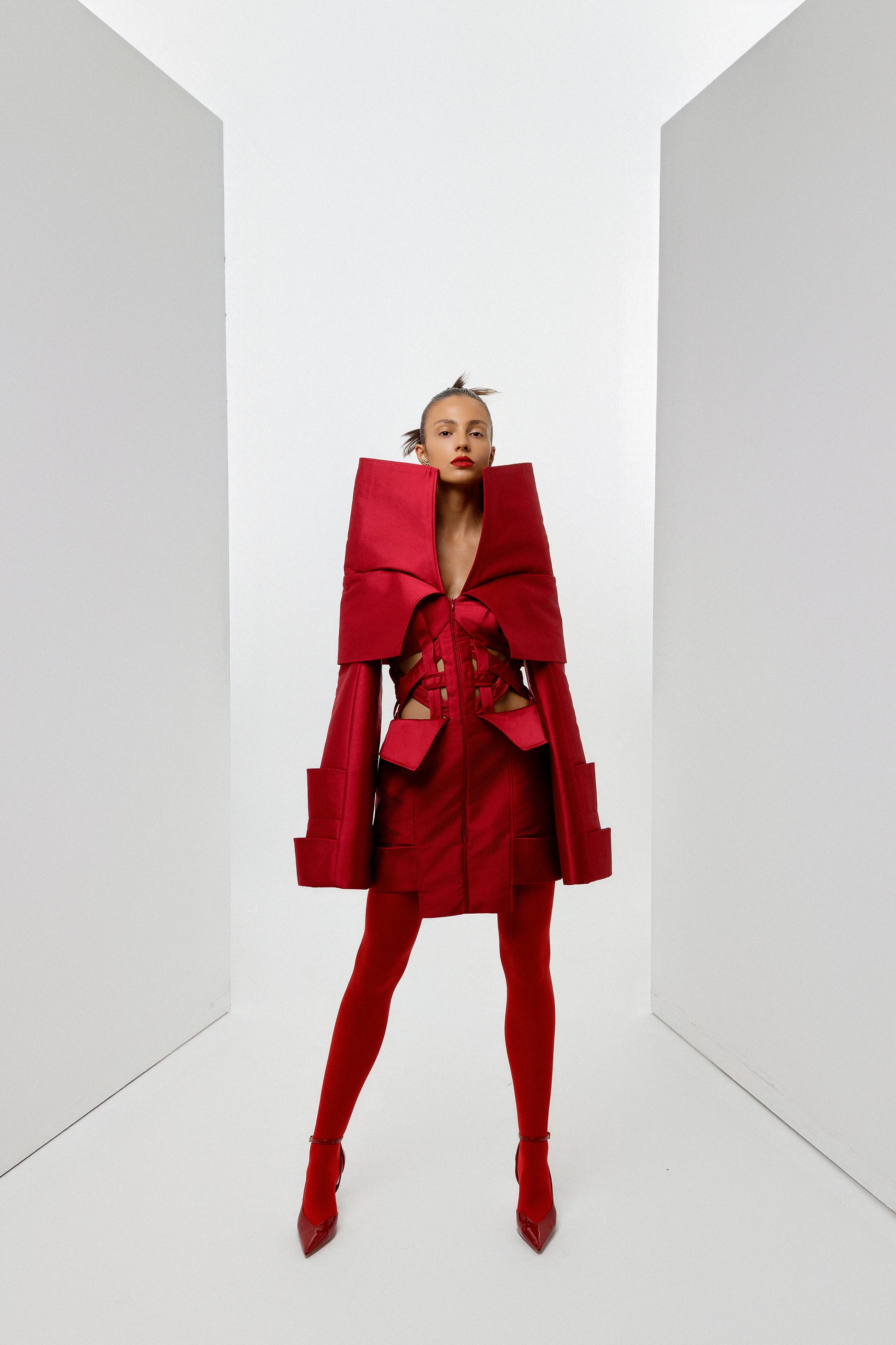 Obsidian Bloom red Mikado editorial mini dress in a symmetrical full-length portrait with sculptural high collar and architectural corset detailing by FlyandFall
