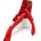 Obsidian Bloom red Mikado editorial dress in wide-angle seated portrait with sculptural high collar and elongated architectural sleeves by FlyandFall