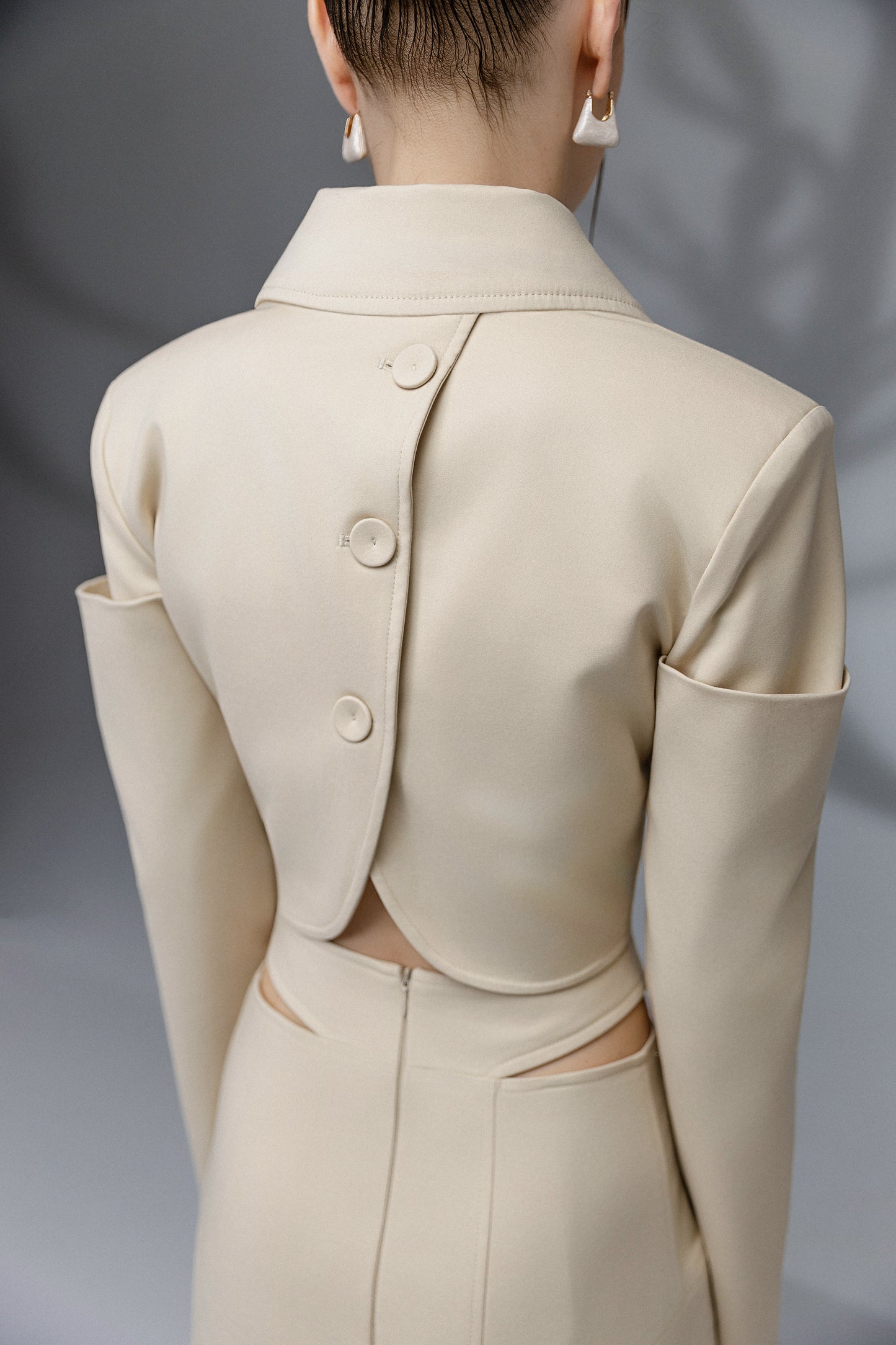 SOLEN sand beige cropped jacket and asymmetric skirt back detail with fabric covered buttons