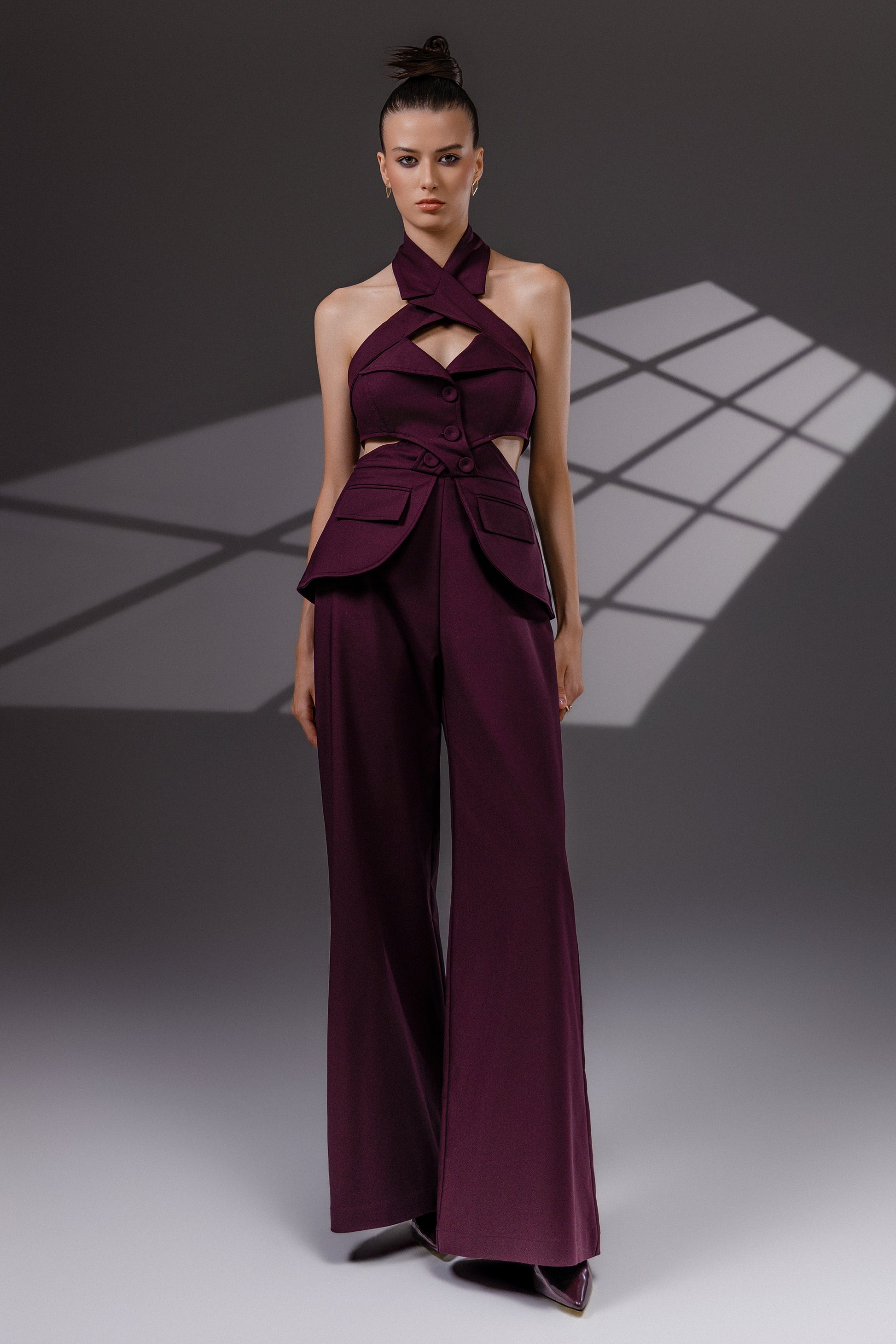 VEYRA Burgundy Crossover Halter Jumpsuit full-length front view with crossover halter neckline, waist cutouts and wide-leg trousers.