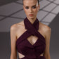 VEYRA Burgundy Crossover Halter Jumpsuit close-up showing the crossover halter neckline, chest cutout, covered buttons and waist cutouts.